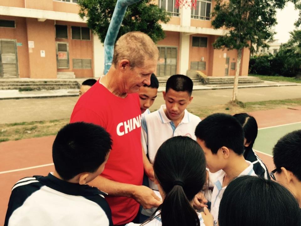 Rick Walrond talks with a group of kids in Shanghai, China. Walrond has coached teams and conducted clinics in the country and many other places around the world.