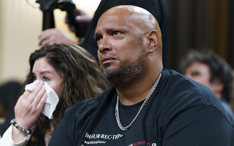 Sandra Garza, left, wipes tears away as Officer Harry Dunn, seated right, gets emotional after seeing video footage during Jan. 6 hearing