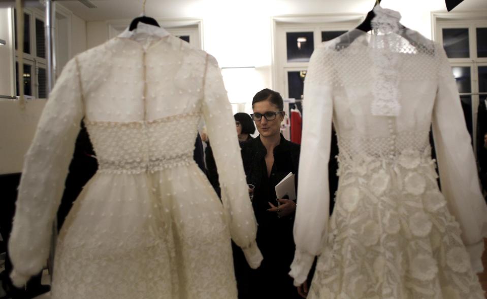 Fashion Designer Maria Grazia Chiuri checks dresses backstage prior the presentation of Valentino's Spring Summer 2013 Haute Couture fashion collection, in Paris, Wednesday, Jan.23, 2013. (AP Photo/Christophe Ena)