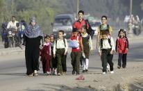 Students walk with their families to school on the first day of their new school year in Giza, south of Cairo September 22, 2013. Students resumed their studies at the beginning of the new academic year this weekend amid parental concerns of a possible lack of security after the summer vacation ends. REUTERS/Mohamed Abd El Ghany (EGYPT - Tags: POLITICS EDUCATION)