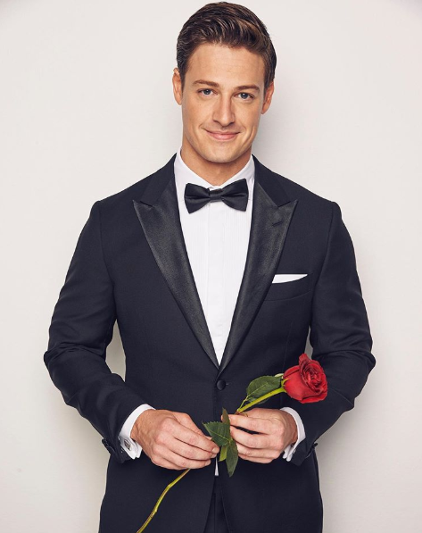 A photo of The Bachelor Australia Matt Agnew wearing a tuxedo and holding a red rose.