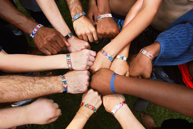 <p>Courtesy Experience Camps</p> Campers and counselors show off their friendship bracelets in bonding circle. August 2023