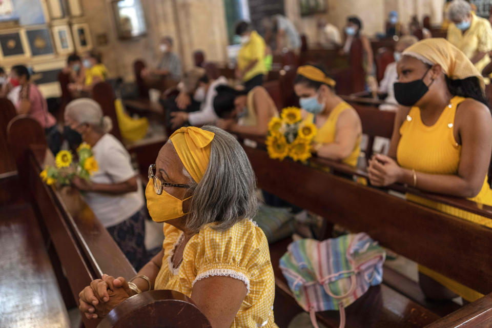People wearing masks amid the COVID-19 pandemic kneel during Mass at Our Lady of Cobre Church on the feast day of Cuba's patron saint, the Virgin of Charity of Cobre, in Havana, Cuba, Wednesday, Sept. 8, 2021. For the second year in a row, the annual procession with the statue of the Virgin of Charity of Cobre was cancelled due to the pandemic. (AP Photo/Ramon Espinosa)