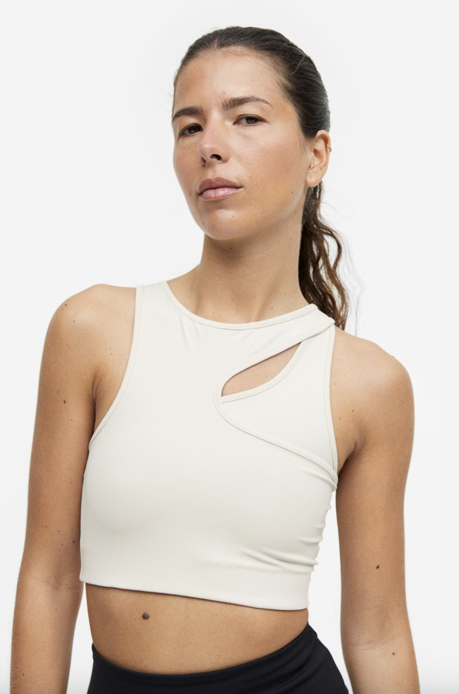 model wearing white DryMove Medium Support Sports Bra (photo via H&M)