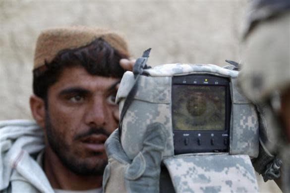 A U.S. Army soldier from 4-73 Cavalry Regiment, 82nd Airborne Division carries out an identification check on an Afghan man with a biometric device during a mission in Zhary district of Kandahar province, southern Afghanistan April 18, 2012.