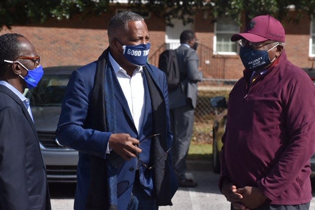 Columbia City Councilman Sam Davis, left, Mayor Stephen Benjamin (center), and Rep. James Clyburn huddled outside a polling place Nov. 3, 2020 in Columbia, S.C. The three have known each other for years.