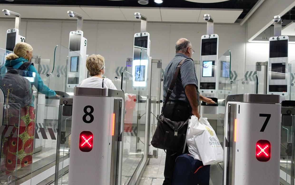 People pass through a passport gate - Police secretly conducting facial recognition searches of passport database