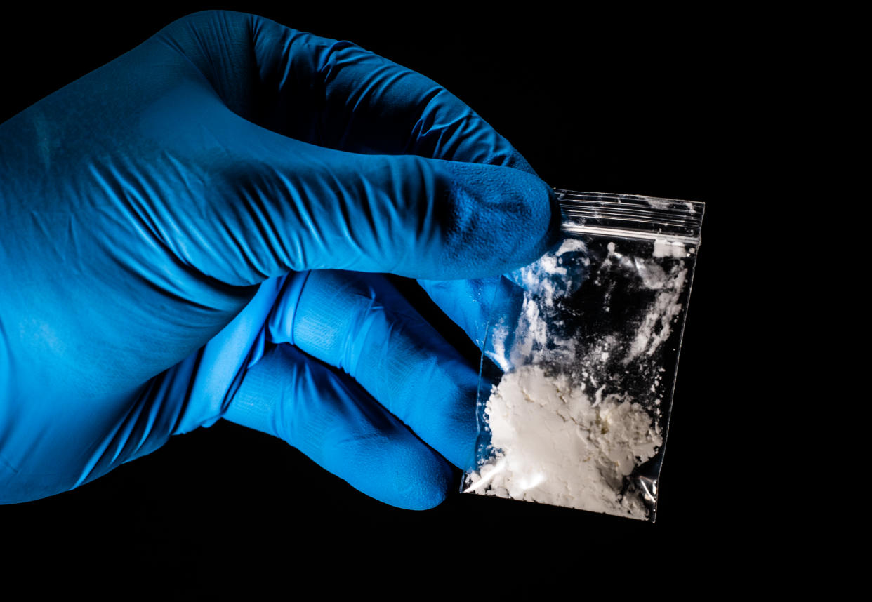 Powdered drugs handled by a blue glove