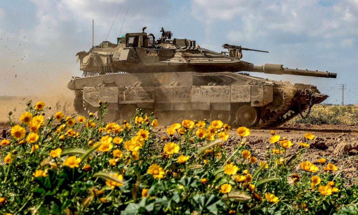 <span>An Israeli tank passes wild flowers near Gaza’s border. The IDF carved new roads out of farmland when it invaded. With much of Gaza’s farms, greenhouses and orchards destroyed, many are asking if the population will be able to grow food any more. </span><span>Photograph: Jack Guez/AFP/Getty</span>