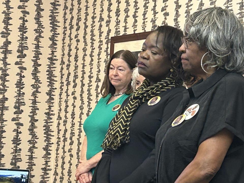 Caroline Ouko, center, the mother of Central State Hospital homicide victim Irvo Noel Otieno, closes her eyes as her attorney Mark Krudys speaks during a news conference Monday, May 6, 2024, at his office in Richmond, Va. Ouko is surrounded by supporters.