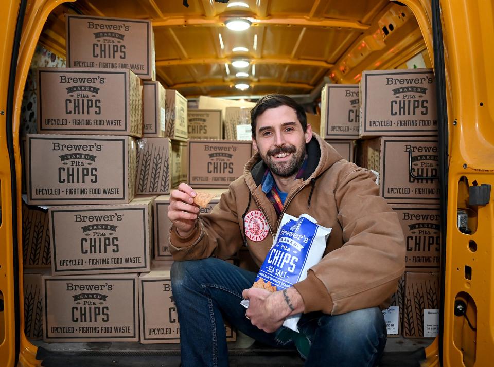 Kyle Fiasconaro, owner of Brewer's Foods, in the back of his van parked at Lamplighter Brewing Company in Cambridge Friday. Fiasconaro makes his crackers, chips and cookies from the left-over grain used for brewing beer at Lamplighter and other breweries.