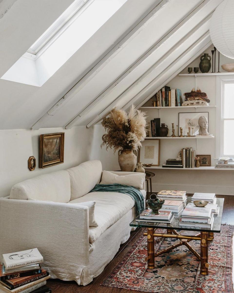 a room with a white couch and a book shelf