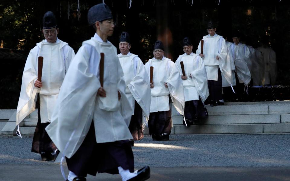 Shinto priests walk during a ritual to usher in the upcoming New Year at Meiji Shrine - ISSEI KATO /REUTERS