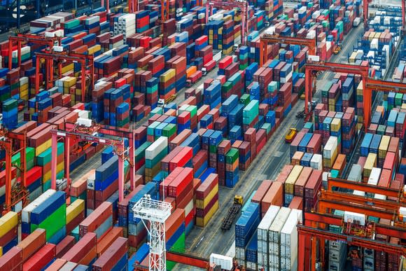 Hundreds of colorful shipping containers being sorted at a port.