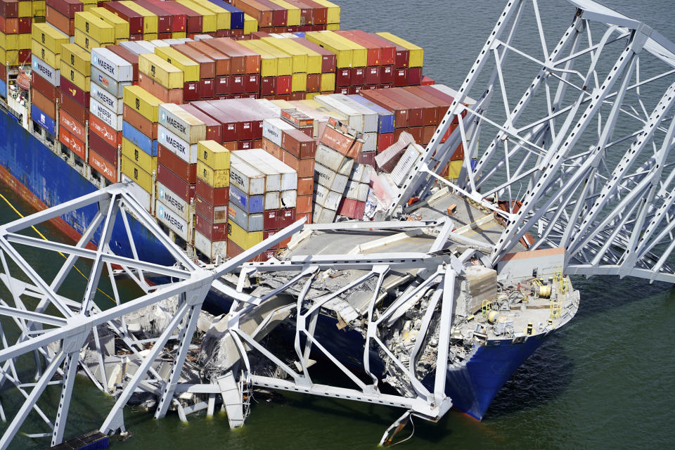 In this aerial image released by the Maryland National Guard, the cargo ship Dali is stuck under part of the structure of the Francis Scott Key Bridge after the ship hit the bridge, Tuesday, March 26, 2024, in Baltimore. (Maryland National Guard via AP)