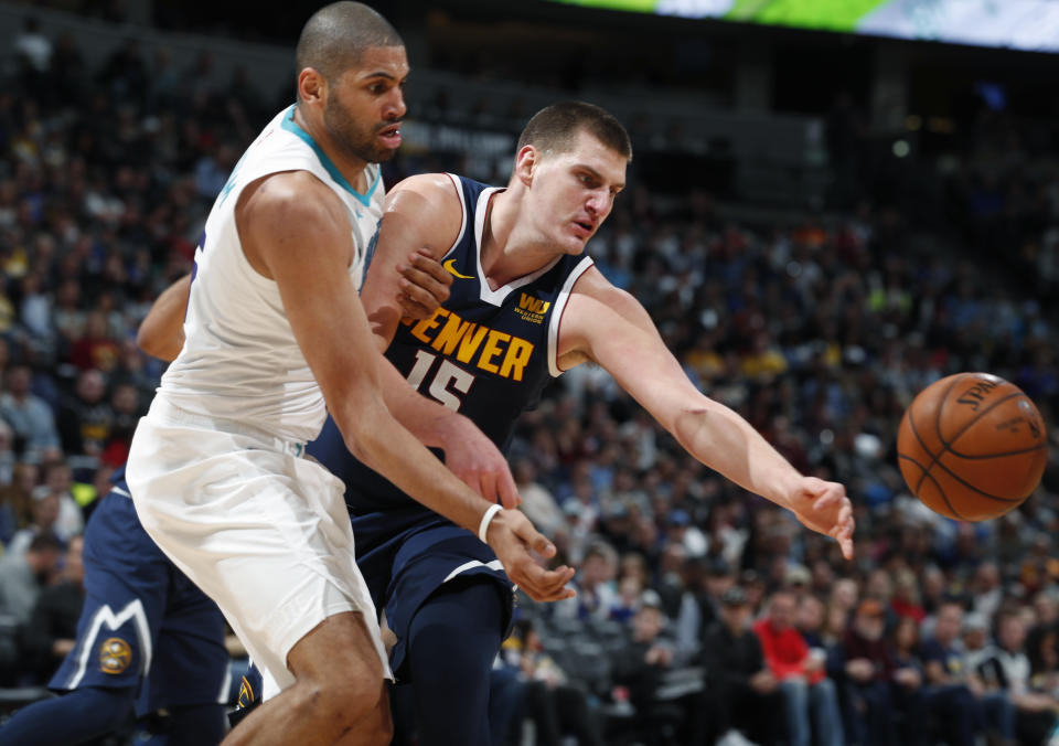 Charlotte Hornets forward Nicolas Batum, left, fights for control of the ball with Denver Nuggets center Nikola Jokic in the second half of an NBA basketball game Saturday, Jan. 5, 2019, in Denver. (AP Photo/David Zalubowski)