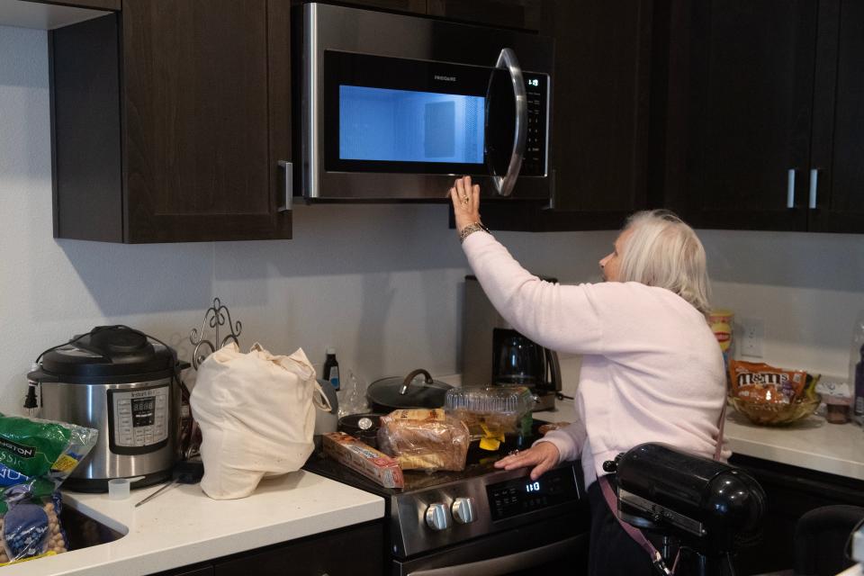 Sandie Moore, 81, has trouble reaching a microwave oven in her kitchen in the Vintage at Anacapa Canyon senior apartments in Camarillo on April 12.