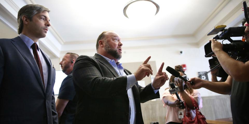 Alex Jones talks to media during a midday break during the trail at the Travis County Courthouse in Austin, Texas, Tuesday, July 26, 2022.