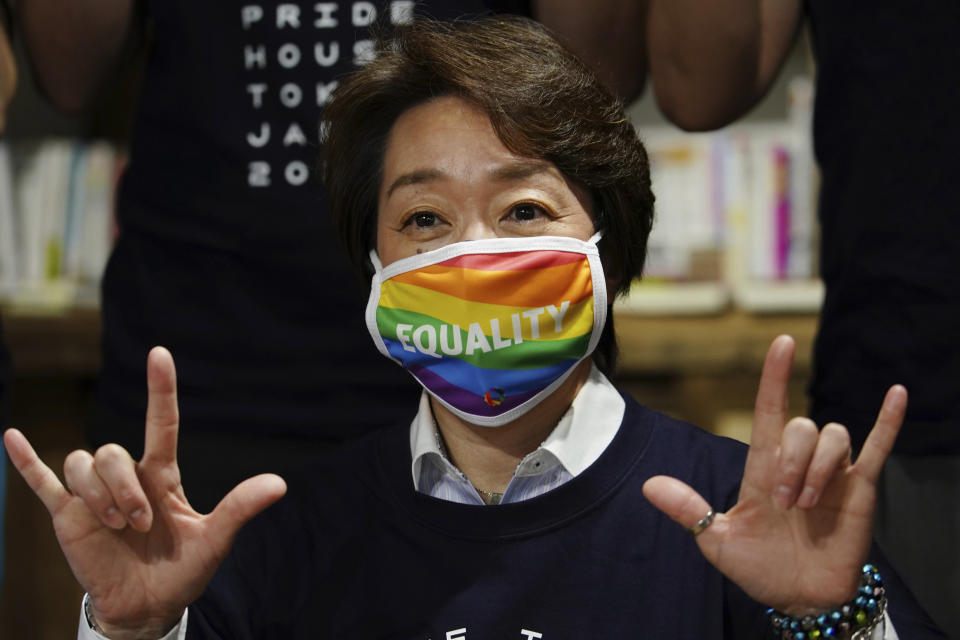 Tokyo 2020 Organizing Committee President Seiko Hashimoto wearing a rainbow-colored mask with word "Equality" poses for a photo with representatives and staff at Pride House Tokyo Legacy during her visit, in Tokyo Tuesday, April 27, 2021. Japan marked LGBTQ week with pledge to push for equality law before the Olympics. (AP Photo/Eugene Hoshiko, Pool)