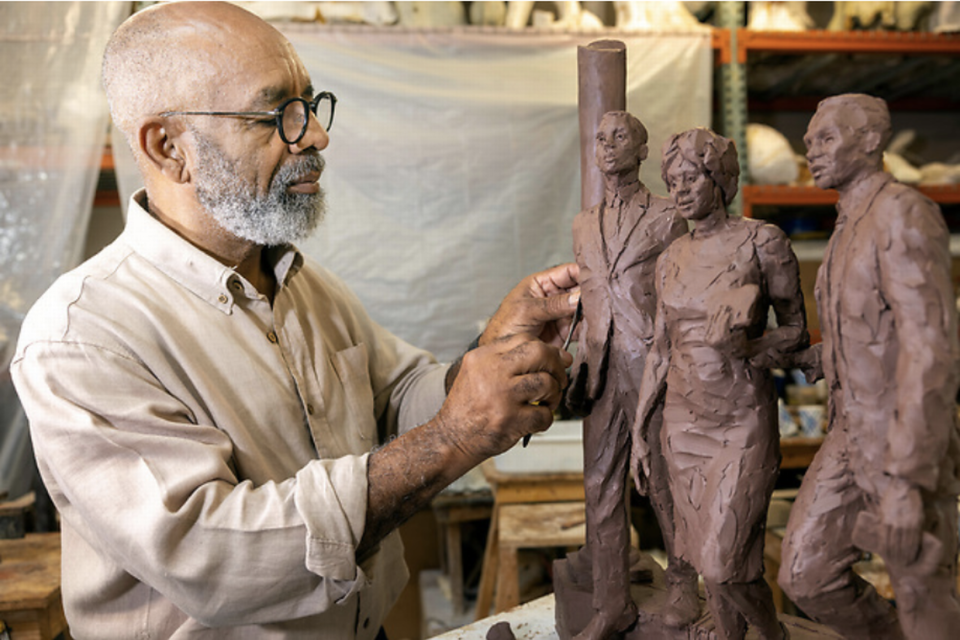 Artist Basil Watson works on a model of the sculpture that will honor three Black students who desegregated the University of South Carolina. The University of South Carolina