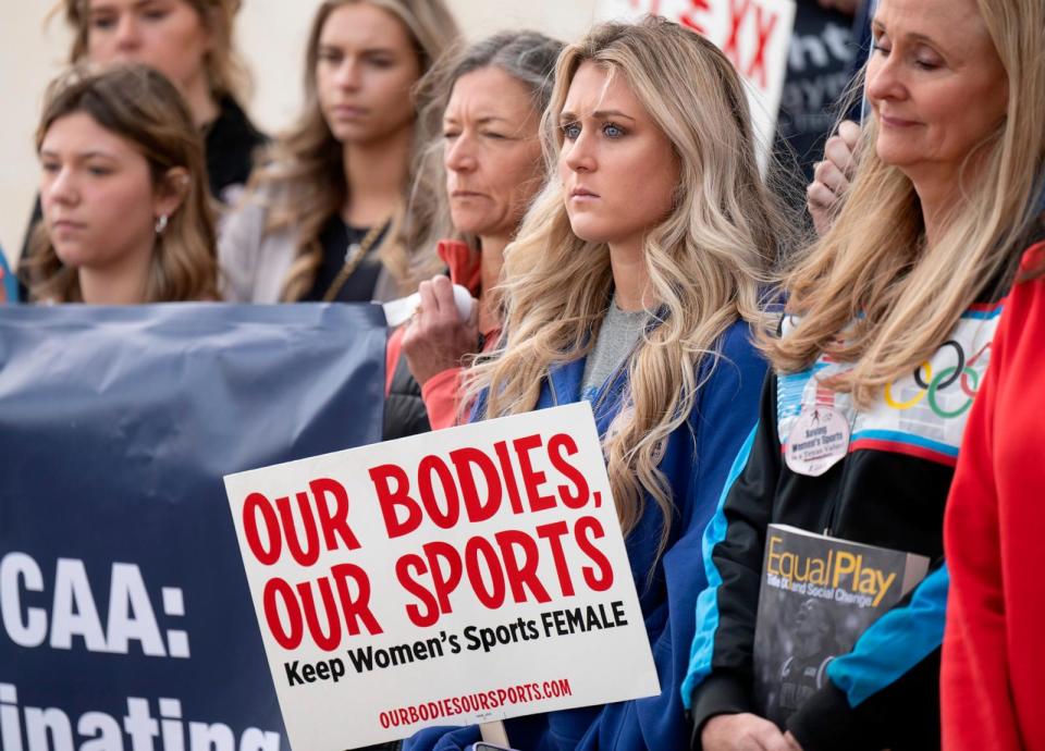 PHOTO: In this Jan. 12, 2023, file photo, former University of Kentucky swimmer Riley Gaines, second from right, stands during a rally outside of the NCAA Convention in San Antonio, Texas. (Darren Abate/AP, FILE)