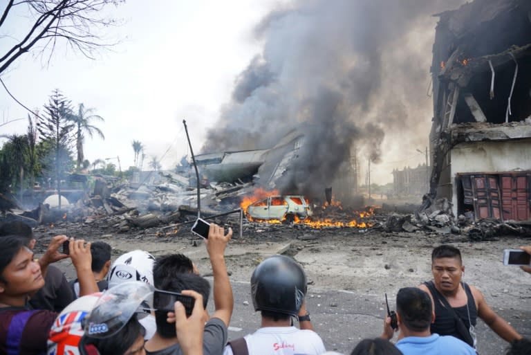 People look at the crash site of a military plane in Medan on June 30, 2015