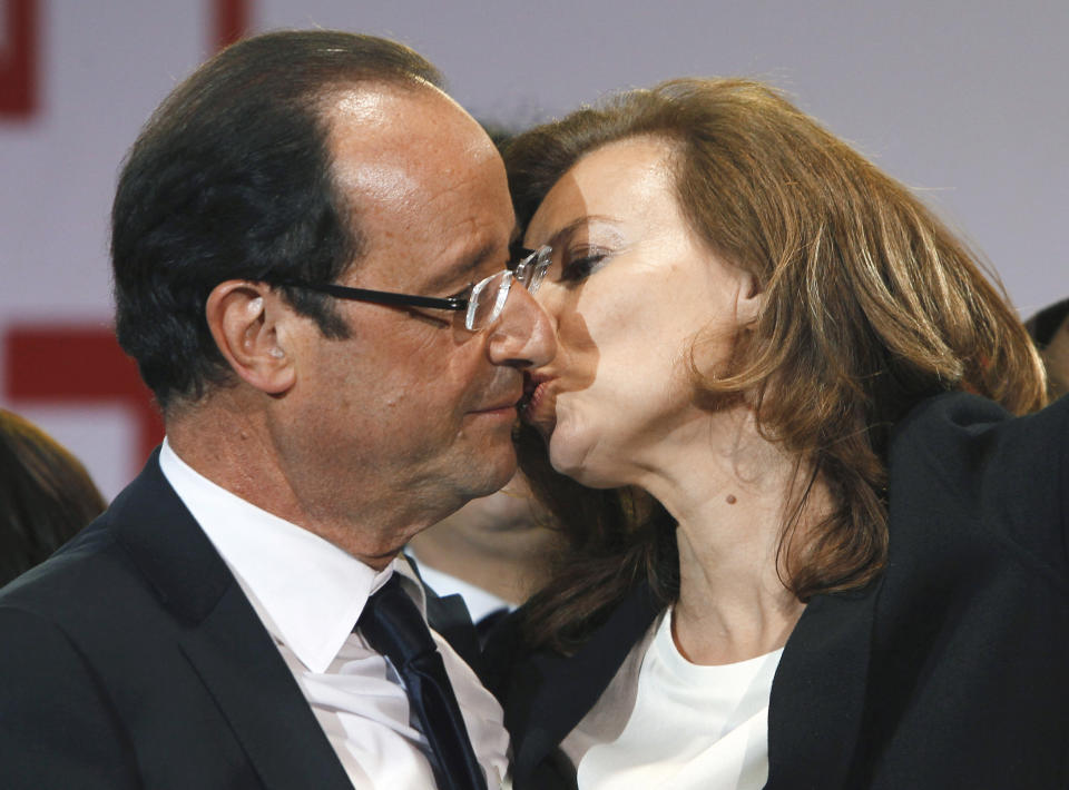 FILE - This Sunday, May 6, 2012, file photo shows French president-elect Francois Hollande kissing his companion, Valerie Trierweiler, after greeting crowds gathered to celebrate his election victory in Bastille Square in Paris. Hollande is threatening legal action over magazine report saying he is having a secret affair with a French actress. The magazine Closer published images Friday Jan.10, 2014 showing his bodyguard and a helmeted man it says is Hollande visiting what it says is the apartment of the actress. (AP Photo/Francois Mori, File)