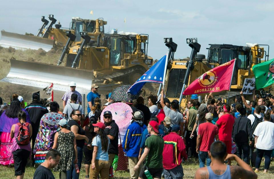 Members of the Standing Rock Sioux Tribe and their supporters confront bulldozers working on the oil pipeline.