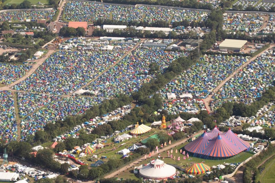 Festival goers cover fields with tents each year (PA)