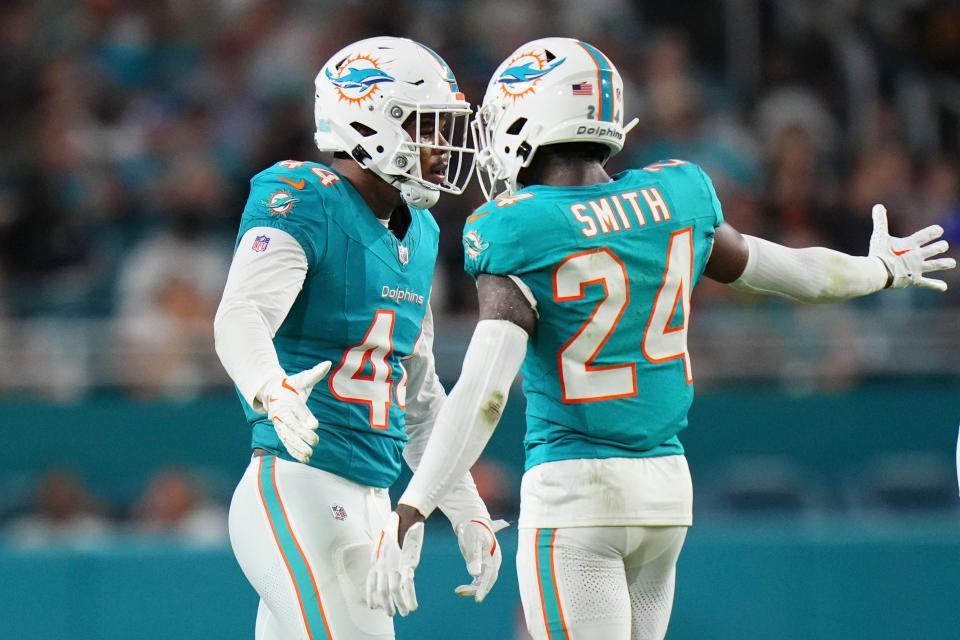 MIAMI GARDENS, FLORIDA - AUGUST 17: Chop Robinson #44 celebrates with Cam Smith #24 of the Miami Dolphins after making a tackle against the Washington Commanders during the second quarter in a preseason game at Hard Rock Stadium on August 17, 2024 in Miami Gardens, Florida. (Photo by Rich Storry/Getty Images)