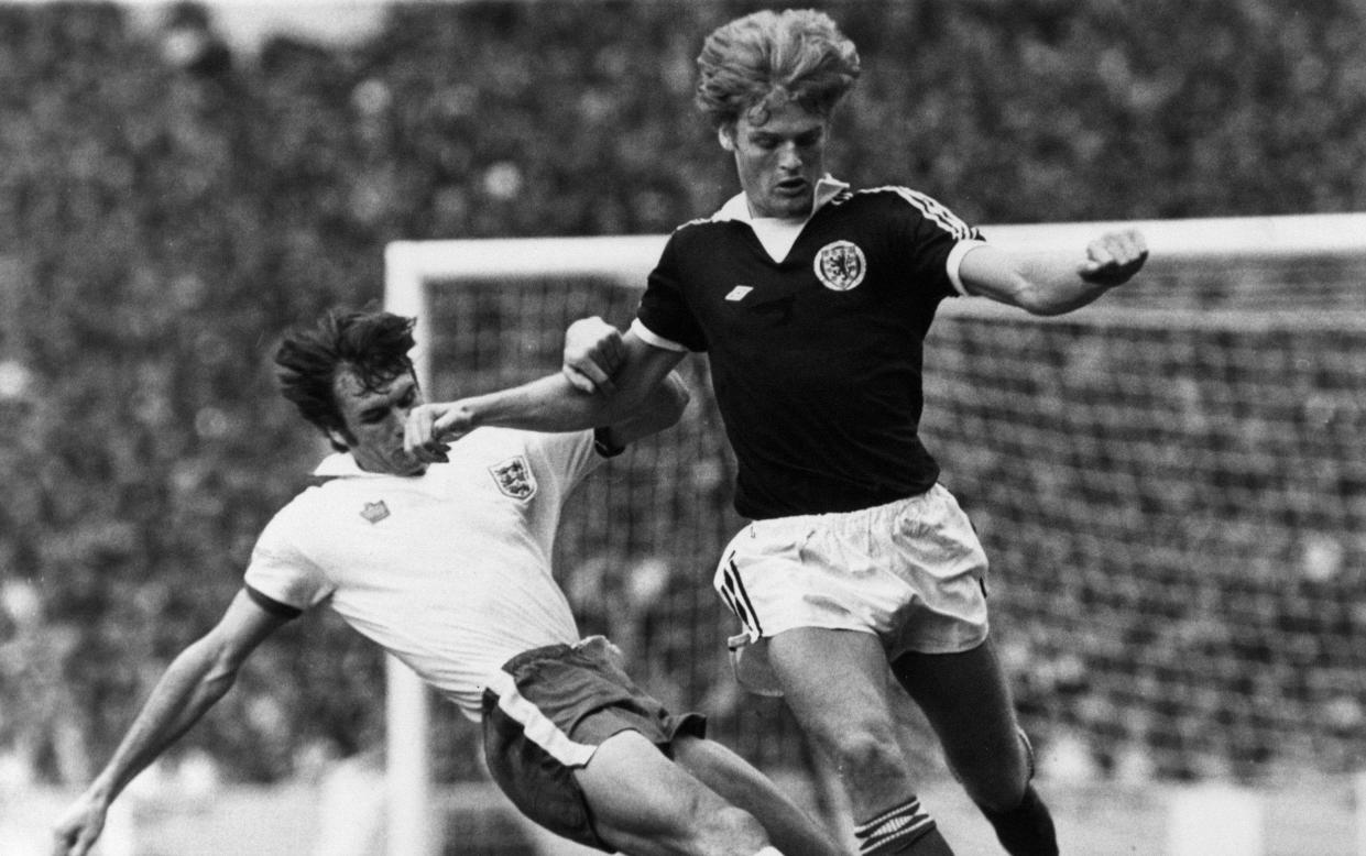 England 1-2 Scotland, British Home Championship, Wembley Stadium, Saturday 4th June 1977; pictured: Gordon McQueen of Scotland is tackled by Dave Watson of England, who seems to get a punch on the nose for his trouble. - GETTY IMAGES