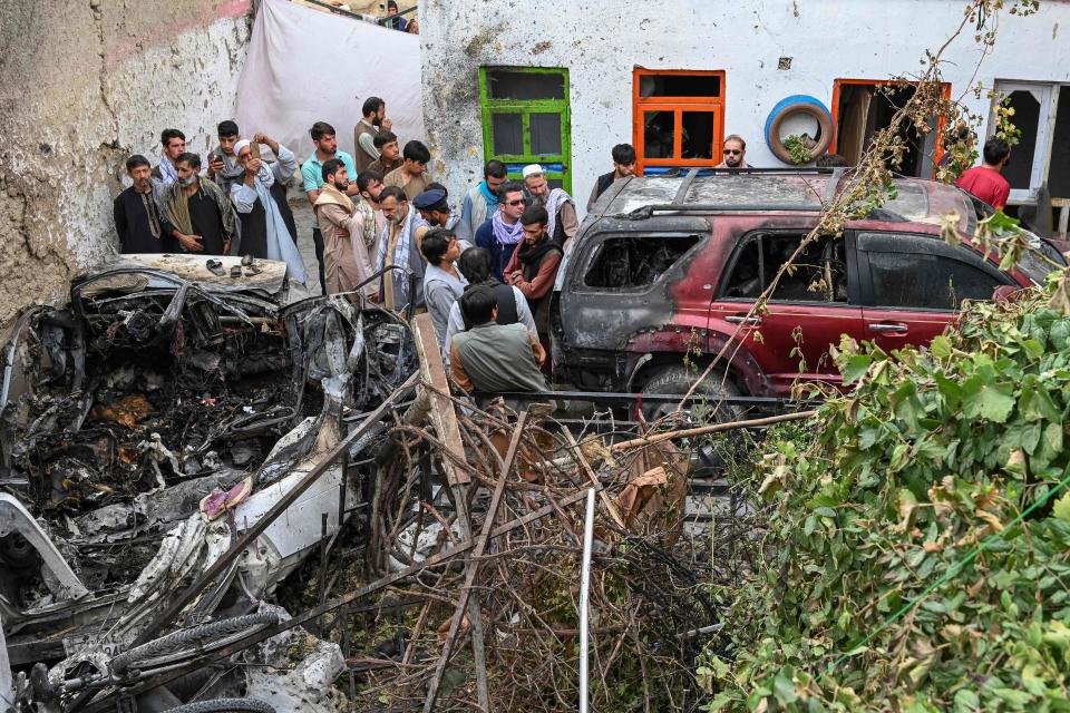 Residents and family members of victims gather next to a damaged vehicle the day after a U.S. drone airstrike in Kabul, Afghanistan, on Aug. 30.