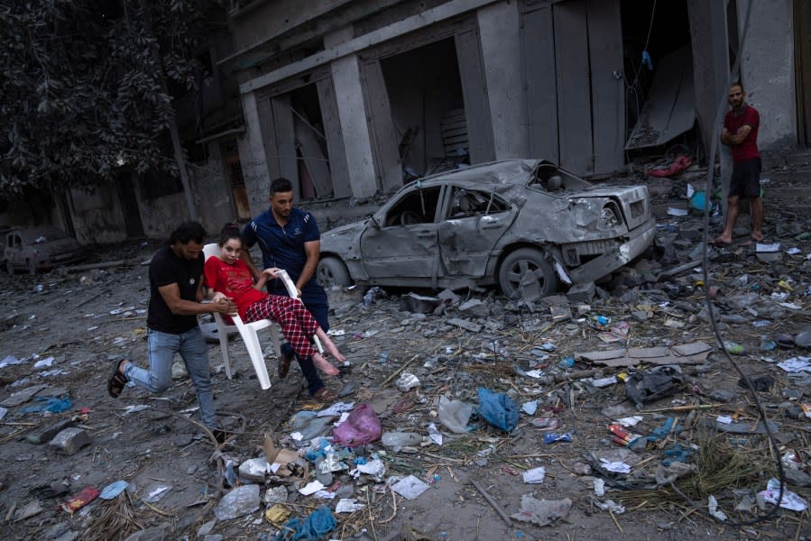 Palestinians walk amid the rubble following Israeli airstrikes that razed swaths of a neighborhood in Gaza City, Tuesday, Oct. 10, 2023. The militant Hamas rulers of the Gaza Strip carried out an unprecedented attack on Israel Saturday, killing over 900 people and taking captives. Israel launched heavy retaliatory airstrikes on the enclave, killing hundreds of Palestinians. (AP Photo/Fatima Shbair)