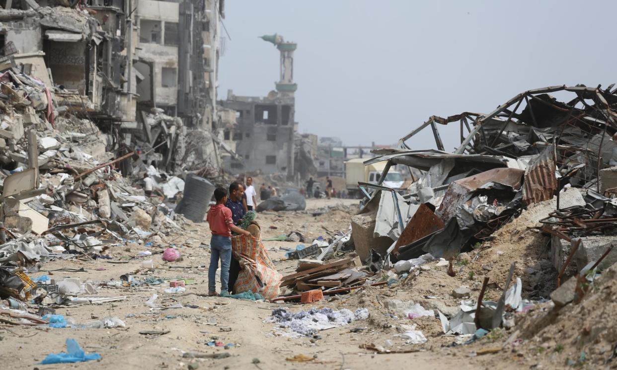 <span>Palestinian families amid rubble after Israeli forces withdrew from Khan Younis, Gaza.</span><span>Photograph: Anadolu/Getty Images</span>