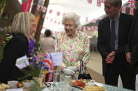 Britain's Queen Elizabeth II, centre, smiles as she meets people from communities across Cornwall as she attends an event in celebration of 'The Big Lunch 'initiative, during the G7 summit in Cornwall, England, Friday June 11, 2021. (Oli Scarff/Pool Photo via AP)