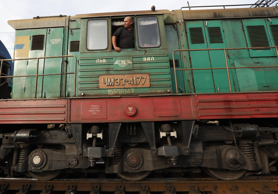 In this Thursday, Oct. 18, 2018 photograph, a railroad engineer looks out of a locomotive at a railroad track gauge changer in Chop, Ukraine. A new education law that could practically eliminate the use of Hungarian and other minority languages in schools after the 4th grade is just one of several issues threatening this community of 120,000 people. Many are worried that even as Ukraine strives to bring its laws and practices closer to European Union standards, its policies for minorities seem to be heading in a far more restrictive direction. (AP Photo/Laszlo Balogh)