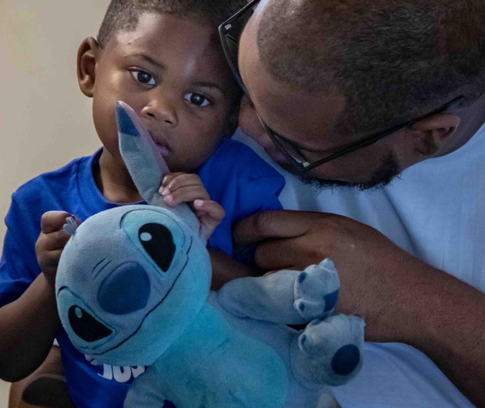 Tiffany Pinkney's son Kendric, 2, and Pinkney's partner and the father of her children, Marquis Lacy, share a moment in the family's Lake Worth Beach apartment.