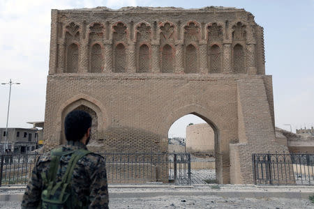 A fighter from Syrian Democratic Forces (SDF) stands near the Baghdad gate in Raqqa, Syria September 16, 2017. REUTERS/ Rodi Said