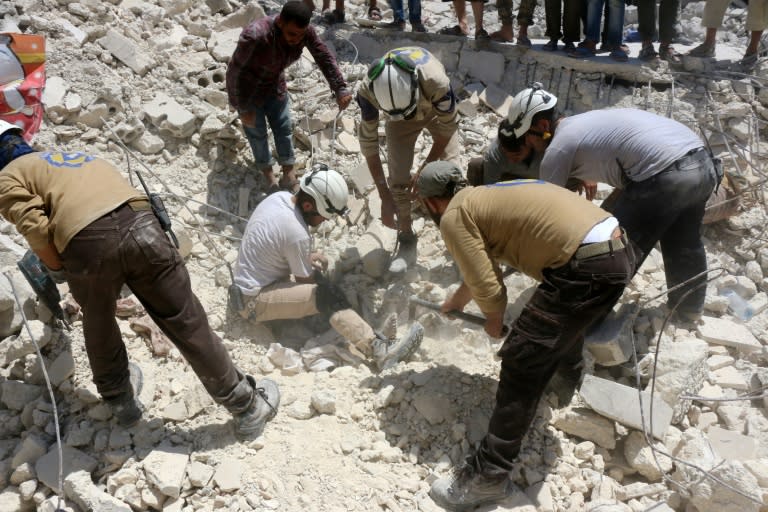 Syrian civil defence workers look for survivors under the rubble of a collapsed building following reported air strikes in a rebel-controlled neighbourhood of Aleppo