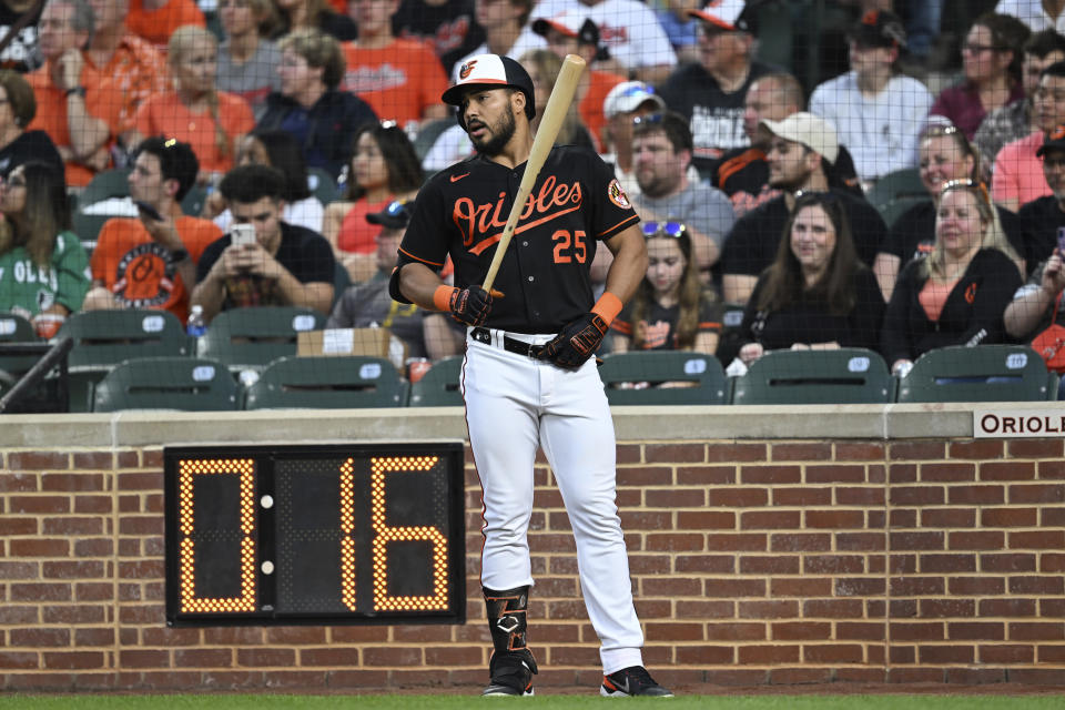 Baltimore Orioles' Anthony Santander waits on-deck next to the pitch clock before batting against the Pittsburgh Pirates during the third inning of a baseball game Friday, May 12, 2023, in Baltimore. (AP Photo/Gail Burton)