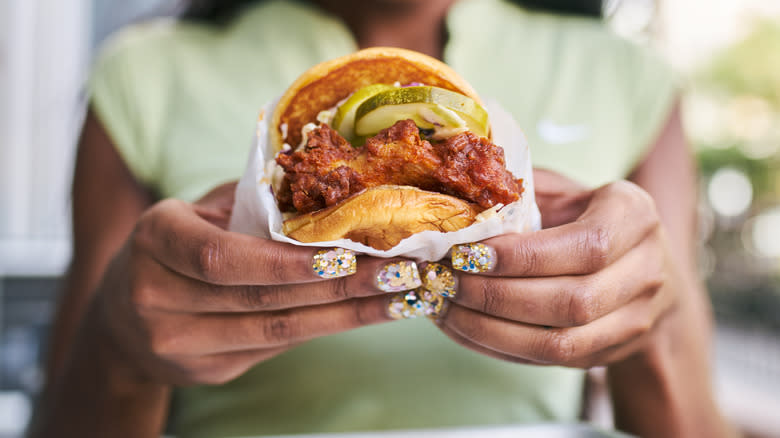 woman holding nashville chicken sandwich