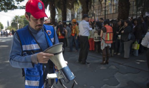 Un miembro de Portección Civil mexicana coordina las tareas de evacuación tras el sismo de este miércoles en México DF.