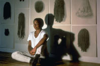 <p>Photographer and multimedia artist Lorna Simpson sits on the floor of her studio in front of her installation <em>Wigs</em>, which explores the history of African American hairstyles and how hair has taken on social and political implications. Simpson investigates identify, race and gender and history through several mediums, including photography, film, drawing, sculpture, installations and video.</p>