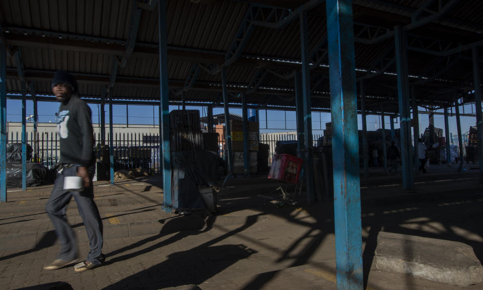 A stranded commuter walks away from a deserted taxi rank in Katlehong, South Africa, Monday, June 22, 2020, as taxi drivers affiliated to the SA National Taxi Council (Santaco) protested against what it believes to be insufficient government relief offered to the industry. South Africa's largest city, Johannesburg, has been hit by a strike by mini-bus taxis, preventing many thousands of people from getting to work on Monday, as the country reopens its economy even as cases of COVID-19 are increasing. (AP Photo/Themba Hadebe)