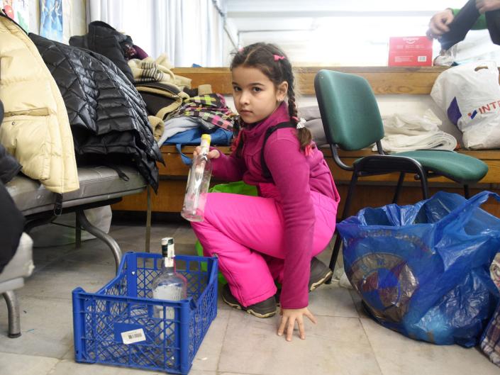 A small girl sorts empty bottles for &quot;Molotov cocktails&quot; at a humanitarian centre in the western Ukrainian city of Lviv on February 27, 2022.