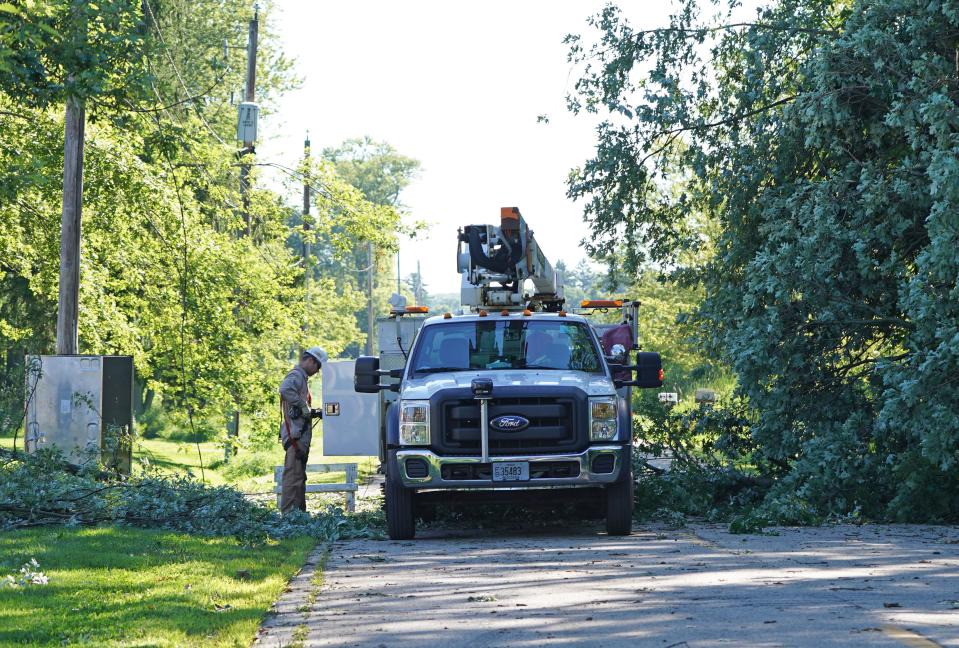 A We Energies worker works near power lines knocked down by a fallen tree on Highway CJ east of Highway 45 in Kenosha County following a storm in 2020.