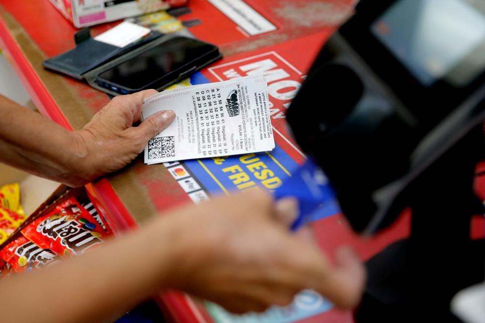 A woman purchases lottery tickets Tuesday, July 26, 2022, inside a store in Edmond.