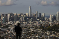 A man looks toward the skyline from Bernal Heights Hill in San Francisco, Monday, March 16, 2020. Officials in six San Francisco Bay Area counties issued a shelter-in-place mandate Monday affecting nearly 7 million people, including the city of San Francisco itself. The order says residents must stay inside and venture out only for necessities for three weeks starting Tuesday in a desperate attempt by officials to curb the spread of the novel coronavirus. (AP Photo/Jeff Chiu)