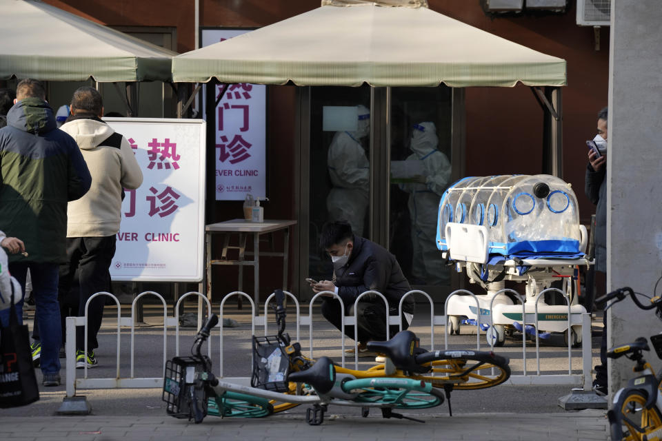 Residents line up outside the fever clinic of a hospital in Beijing, Friday, Dec. 9, 2022. China began implementing a more relaxed version of its strict "zero COVID" policy on Thursday amid steps to restore normal life, but also trepidation over a possible broader outbreak once controls are eased. (AP Photo/Ng Han Guan)