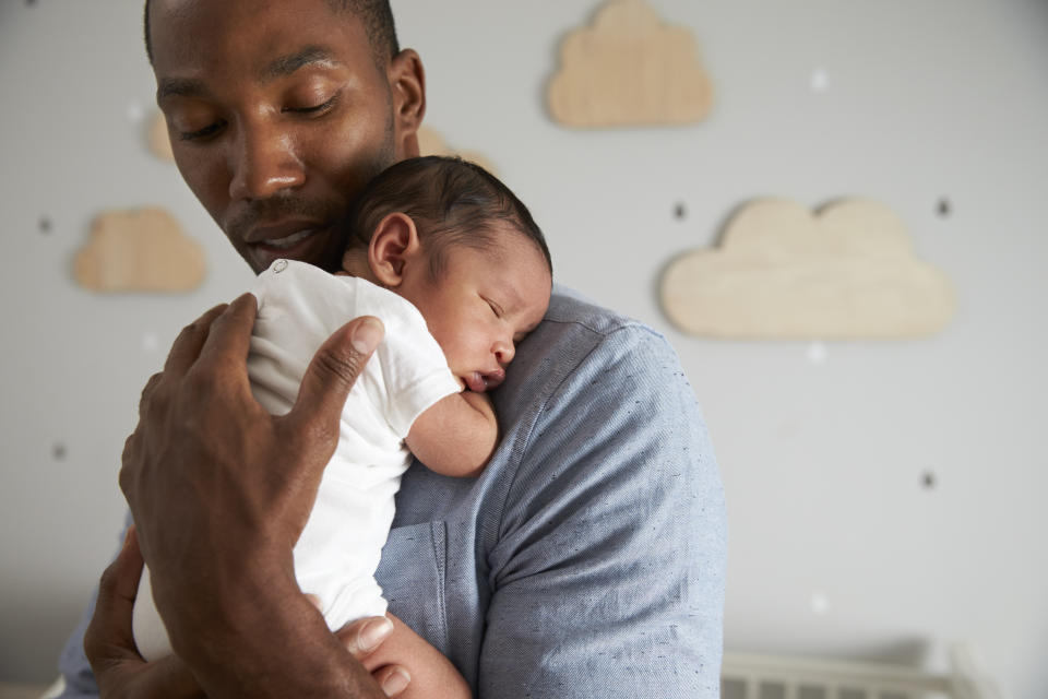 Father holding newborn baby sleeping